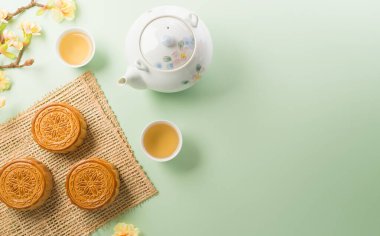Ay çöreği, çay ve erik çiçeğinden yapılan Çin Sonbahar Festivali konsepti pastel arka planda.