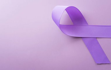Purple ribbon on pastel paper background for supporting World Cancer Day campaign on February 4.