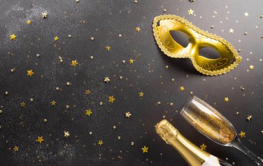 Happy Purim carnival decoration concept made from golden mask star and glitter on dark background. (Happy Purim in Hebrew, jewish holiday celebrate)