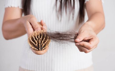 Sağlıklı bir kavram. Kadın hasarlı uzun saçlı ve saçlarına bakarak onu fırça göstermek.