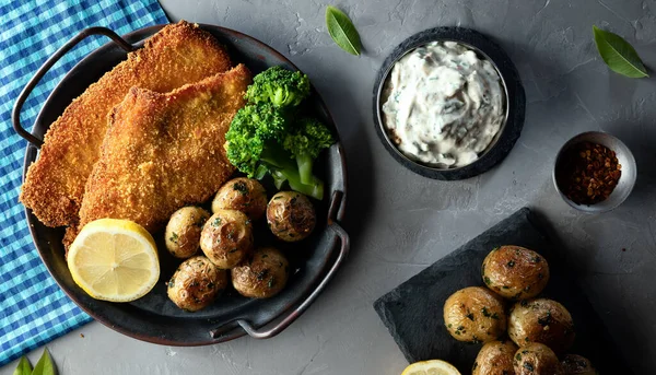 Schnitzel - traditional Austrian (German) breaded meat with potatoes, sauce and spices
