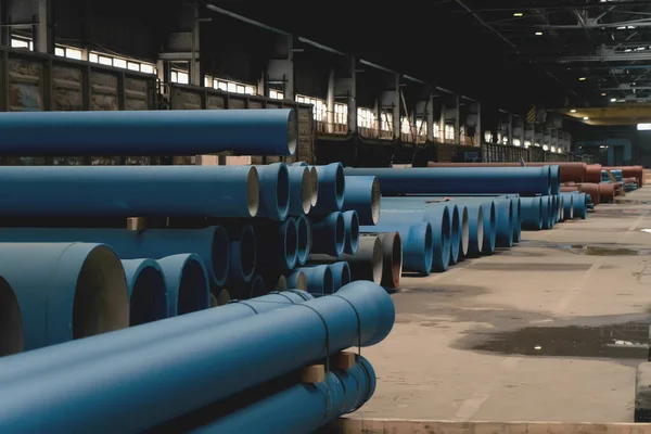 New cast iron pipes with for pipeline construction in warehouse factory interior.