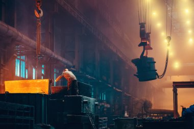 Metalürji fabrikasının içi. Dökümhane işçisi demir kalıpları için büyük küf kullanıyor. Ağır endüstri. Çelik fabrikası.