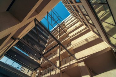 Modern yellow building viewed upwards from the inner courtyard of the well.