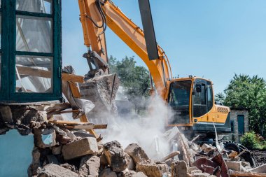 Demolition of building. Excavator destroy old house.