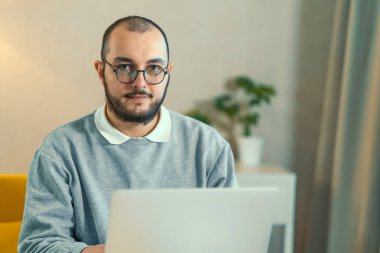 Male freelancer or IT code developer working at laptop. Programmer or young businessman at home office, distant job.