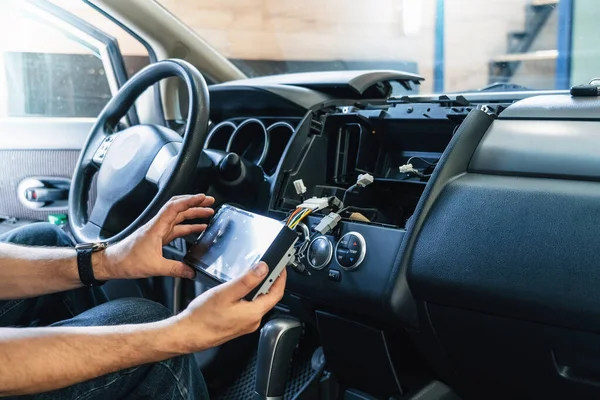 stock image Auto in Car Service, process of installing modern 2-din radio sound system. Auto electric hands on dashboard fixing problem close-up.