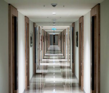 Otelde uzun bir koridor, büyük pencerenin sonunda bir sürü kapı ve ışık var..