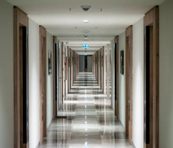 Długi Korytarz Hotelu Wieloma Drzwiami Światłem Końcu Dużym Oknem — Zdjęcie stockowe