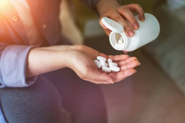 Beyaz tabletler ya da haplar ya da kız elinde beslenme takviyeleri. Ağrı kesicilere uyuşturucu bağımlılığı. Evde hastalıkların tedavisi.