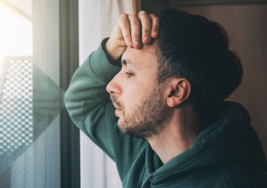 Yorgun adam pencereye bakıyor. Orta yaş bunalımında ya da sorunları olan üzgün bir orta yaş insanı. İş depresyonu ya da iflas kavramı.