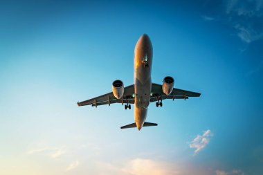 Ticari uçak jeti, dramatik bulut arka planında uçuyor. Seyahat ulaşım kavramı.