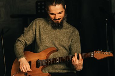 Gitarist gitar çalar. Müzik kayıt stüdyosu ya da grup provası ve pratik kavramı.