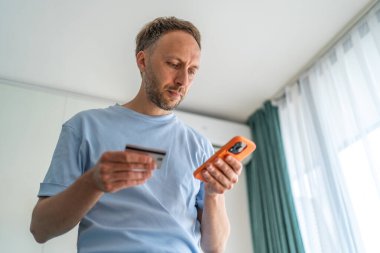 Adam kart detaylarını telefonuna girip online alışveriş yapıyor..