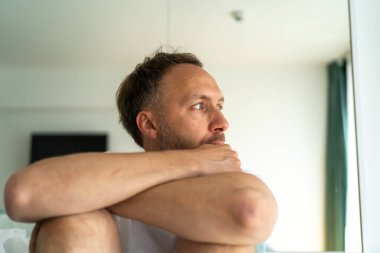 Evde tek başına üzgün orta yaşlı bir adam. Duygusal stres, tükenme ve orta yaş krizi konsepti.