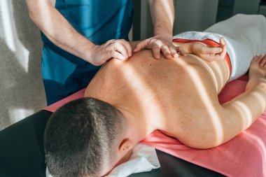 Masaj terapisti hastaya masaj yapıyor, yakın plan. Sağlık ve canlandırma masajı ve spa tedavileri.