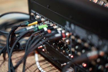 Profesyonel ses karıştırıcıya, detaylı bağlantılara ve kablolara bağlı ses kabloları. Modern ses teknolojisi ve kayıt ekipmanları stüdyo ortamında.