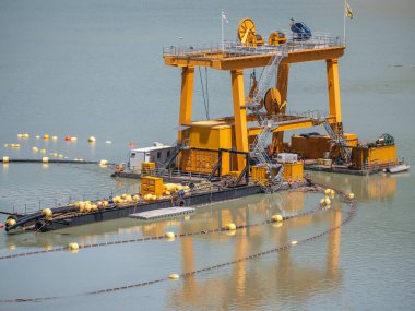 Sarı sanayi vinci Enguri barajında yüzen platformda, hidroelektrik enerji üretiminde bakım ve işlemler için gereklidir..