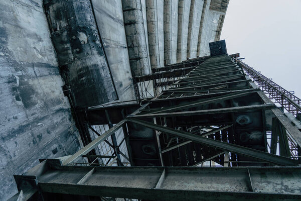 Вид снизу на промышленную структуру с металлическими балками и бетоном, масштаб и сложность проектирования и строительства.