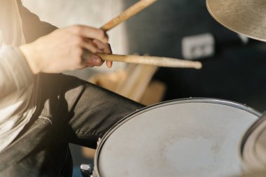 Davulcu elleri bagetlerle trampet çalıyor, yakın plan..