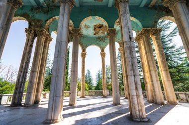 Columns in abandoned Medea sanatorium in Tskaltubo, Georgia. Sunlight shines through tall pillars, architectural beauty and signs of decay in historic structure. clipart