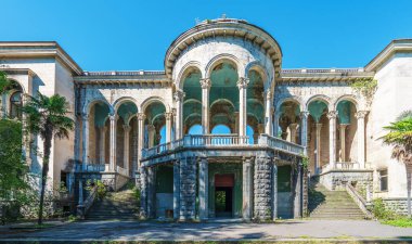 Georgia, Tskaltubo 'da terk edilmiş bir sanatoryum. Uzun kolonları ve büyük kemerleri olan neoklasik mimari doğa tarafından çevrelenmiş çürüme belirtileri gösteriyor..