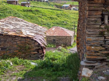 Georgia, Svanetian köyünde ahşap çatılı taştan evler. Yeşillik, geleneksel mimari ve mirasın sergilendiği manzaralı dağ yerleşkesi..