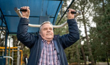 Egzersiz yapan yaşlı bir adam, açık hava spor salonu, yaşlılık, aktif yaşlanma, sağlıklı yaşam tarzı, fiziksel egzersiz, dayanıklılık eğitimi, refah.