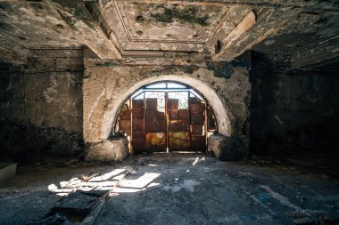 Terk edilmiş bir oda, paslı bir kapı, pencereden içeri giren güneş ışığı, yıpranmış duvarlar, yere saçılmış tavan, yere saçılmış enkaz, ürkütücü atmosfer, korku, keşif ve sanat temaları için mükemmel..