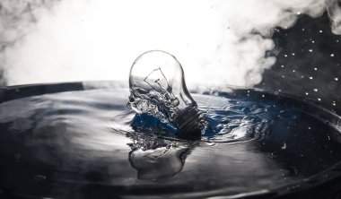 Soyut kavram. Ampulün suya düşmesi ya da sisli zemine su sıçraması. Seçici odak.