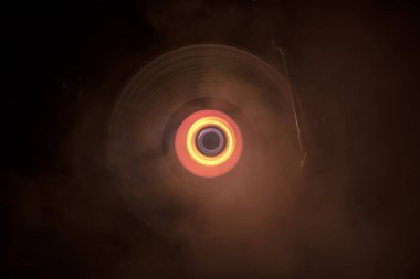 Müzik Dj konsepti. Yangın ve duman vinil kayıt üzerinde iz. Vinil disk yazma. Pikap vinil plak çalar koyu arka plan üzerinde. Seçici odak