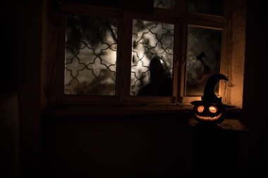 Geceleri mistik evdeki korkunç Cadılar Bayramı balkabağı ya da penceredeki cadılar bayramı balkabağı ve korku silueti. Seçici odak