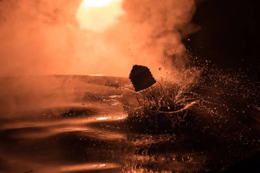 Soyut kavram. Ampulün suya düşmesi ya da sisli zemine su sıçraması. Seçici odak.