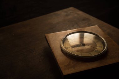Time concept. Old rustic wall clock on old wooden table with copy space studio shot