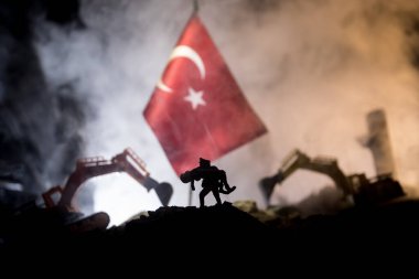 Turkey Earthquake happend in February 2023. Decorative photo with Turkish flag, and ruined city buildings. Pray for Turkey. Selective focus