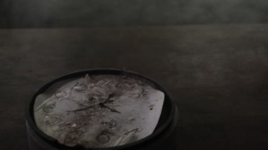 Old and vintage blank clock dial without hand on old wooden table. Studio shot