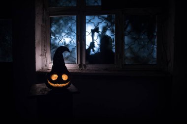 Geceleri mistik evdeki korkunç Cadılar Bayramı balkabağı ya da penceredeki cadılar bayramı balkabağı ve korku silueti. Seçici odak