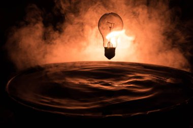 Soyut kavram. Ampulün suya düşmesi ya da sisli zemine su sıçraması. Seçici odak.