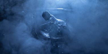 Soyut kavram. Ampulün suya düşmesi ya da sisli zemine su sıçraması. Seçici odak.