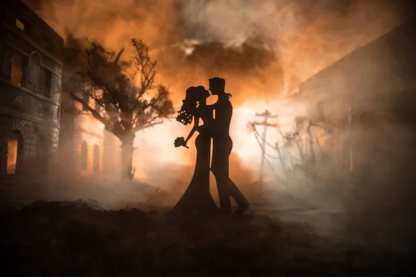 Nuclear war apocalypse and love until death concept. Romantic couple during atomic war. Creative artwork decoration in dark. Selective focus