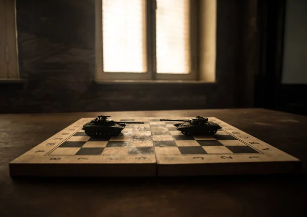 War between Russia and Ukraine, conceptual image of war using chess board and tank on a dark background. Ukrainian and Russian crisis, political conflict. Selective focus