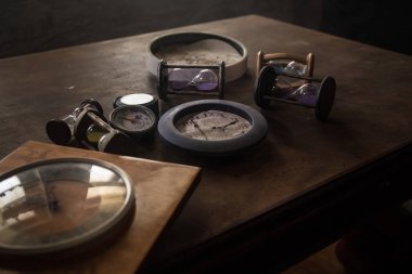 Time concept. Many clocks on old wooden table with copy space studio shot