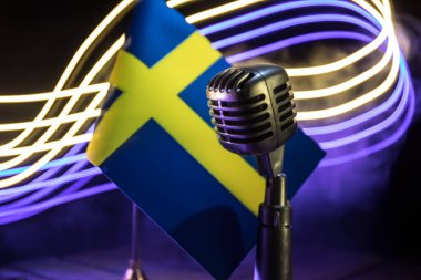Microphone on a background of a blurry flag Sweden close-up. dark table decoration. Selective focus