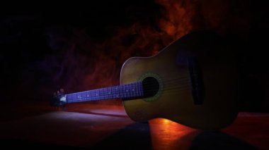 Müzik konsepti. Akustik gitar ile kopya alanı dumanla ışık demeti altında karanlık bir arka plan üzerinde izole. Gitar telleri, yakın çekim. Seçici odak.