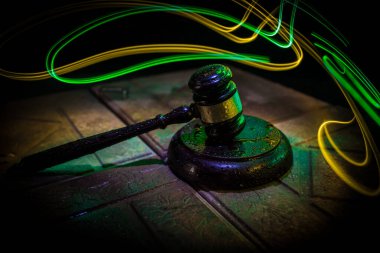 Hukuk teması: Hakimin tahta masadaki tokmağı. Kanun tokmağı sisli arka planda, aydınlık. Seçici odak