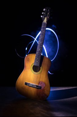 Müzik konsepti. Akustik gitar ile kopya alanı dumanla ışık demeti altında karanlık bir arka plan üzerinde izole. Gitar telleri, yakın çekim. Seçici odak.