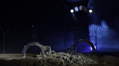 Ceza adaleti hapsi konsepti. Kelepçe ve eski hapishane gözetleme kulesi geceleri tel örgülerle korunuyor. Yaratıcı sanat dekorasyonu. Seçici odak