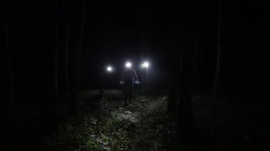 Alnında fenerle ormanda bir adam 