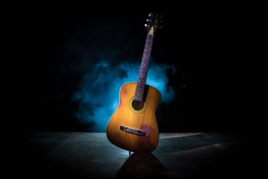 Müzik konsepti. Akustik gitar ile kopya alanı dumanla ışık demeti altında karanlık bir arka plan üzerinde izole. Gitar telleri, yakın çekim. Seçici odak.