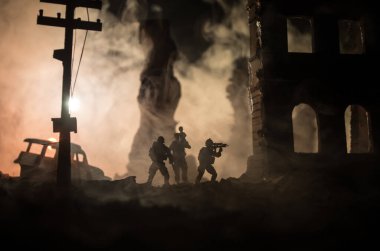 Silüet asker, küçük çocuğu ateşten omuzunda taşıyor. Kurtarıcı konsepti. Yanmış şehirden küçük bir çocukla taşınan adam savaşta yok oldu. Seçici odak